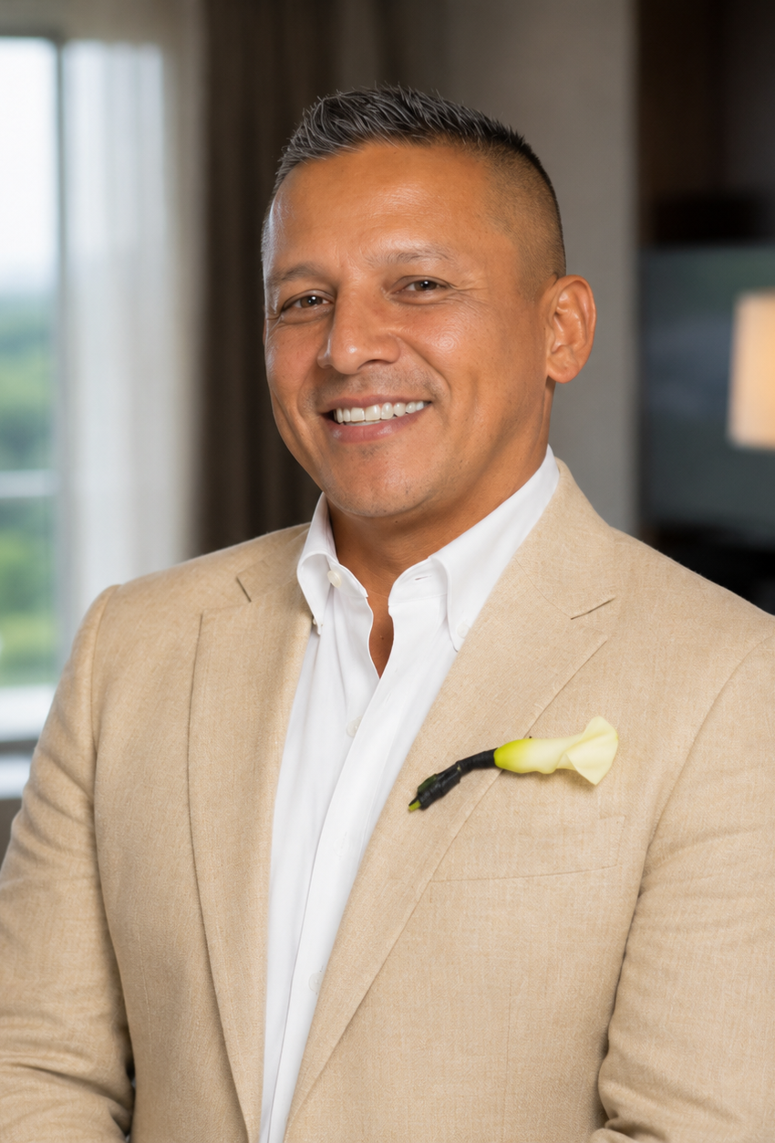 Professional headshot of Alberto Gerardini, licensed health insurance agent at Affordable Care Agents, wearing a light tan suit jacket with a softly blurred office background.